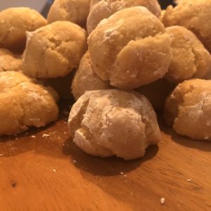 A close-up pile of almond bites on a wooden board.