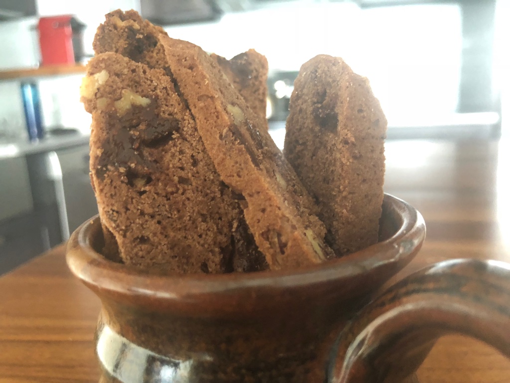 Image of several double chocolate biscotti with sliced nuts.