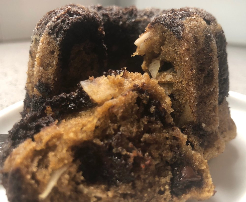 Image of a double coconut double chocolate mini breakfast breads broken in half to show the inside.
