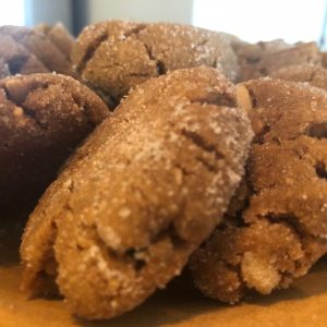 Image of several perfect peanut butter cookies on a wooden board.