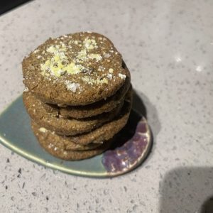Tumeric black pepper ginger shorties stacked 5 high on a small green and viotel dish.